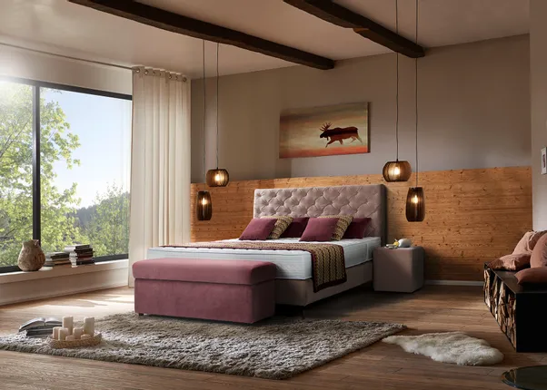 Modernes Schlafzimmer mit Polsterbett, Holzakzenten und großen Fenstern mit Blick ins Grüne