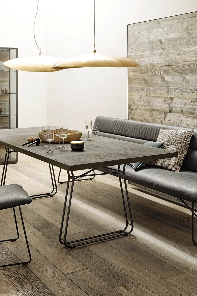 Modernes Esszimmer mit Holztisch, grauen Lederstühlen und Bank vor Holzverkleidung