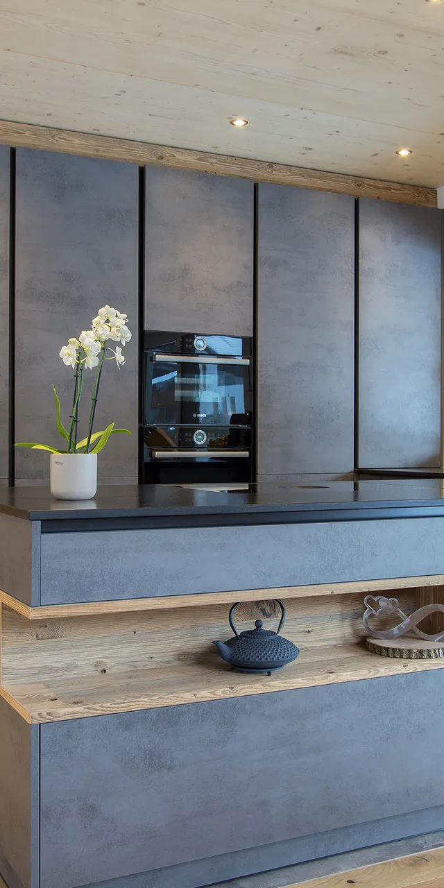 Moderne Küche mit grauen Schränken, Kochinsel und eingebautem Ofen