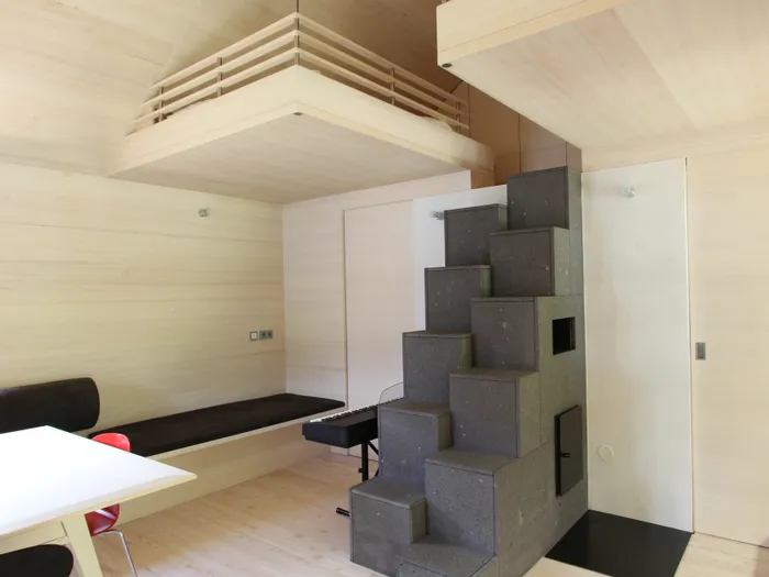 Moderne minimalistische Wohnraumgestaltung mit Holzinterieur und geometrischer Treppe
