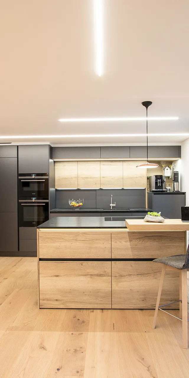 Moderne Küche mit Holzdetails, Kochinsel, Hockern und großen Fenstern mit Vorhängen