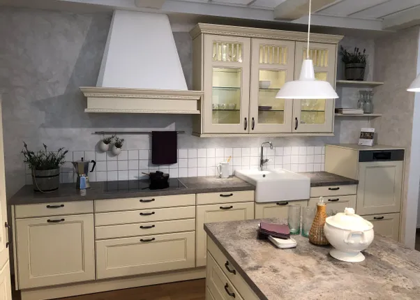 Klassische Landhausküche mit cremefarbenen Schränken, Spülbecken und Kücheninsel aus Steinoptik