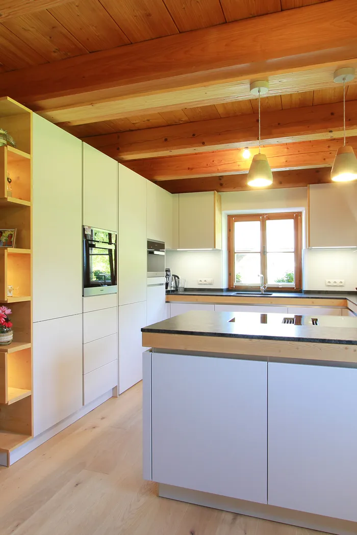 Moderne offene Küche mit Holzdecke, Kochinsel und integriertem Regal mit Beleuchtung