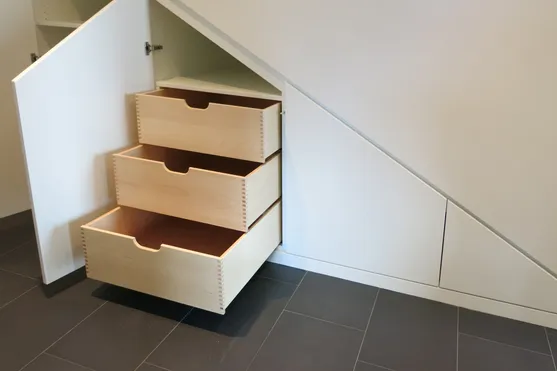 Maßgeschneiderte Holzschubladen unter einer Treppe als platzsparende Aufbewahrungslösung