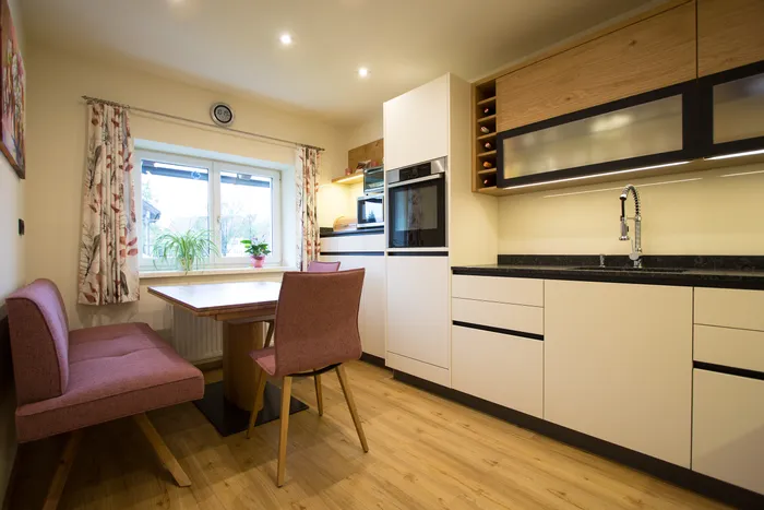 Moderne Einbauküche mit Essbereich, Holzfußboden und pastellfarbenen Möbeln