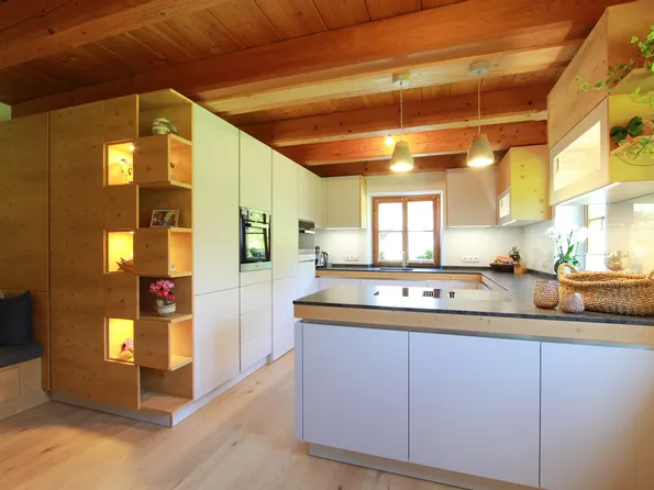 Moderne offene Küche mit Holzdecke, Kochinsel und integriertem Regal mit Beleuchtung