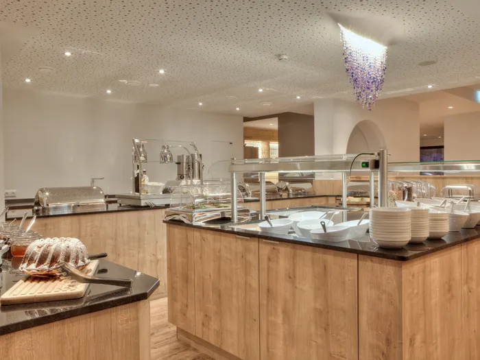 Modernes Hotelbuffet mit Holzverkleidung, Frühstücksschüsseln, Joghurt und Marmeladen