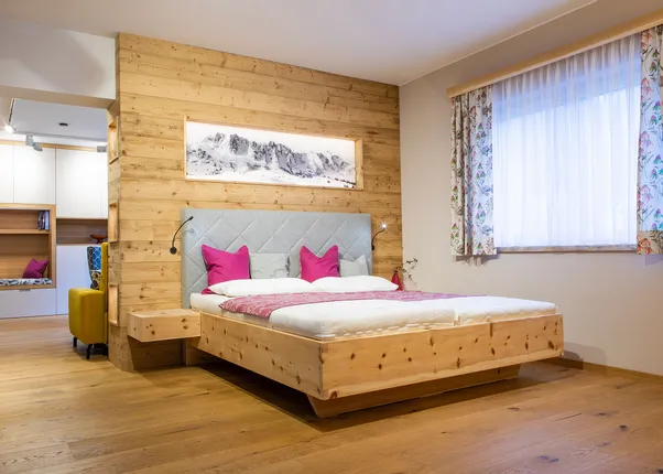 Modernes Zirbenbett mit Kopfteil mit Lodenstoff