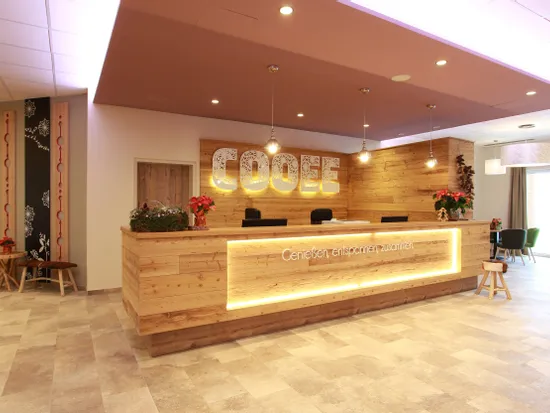 Modern gestalteter Empfangsbereich mit Holztheke und dekorativer COOFFE-Beschriftung