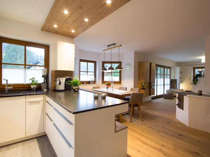 Moderne offene Wohnküche mit Holzdetails, Essbereich und gemütlichem Wohnzimmer