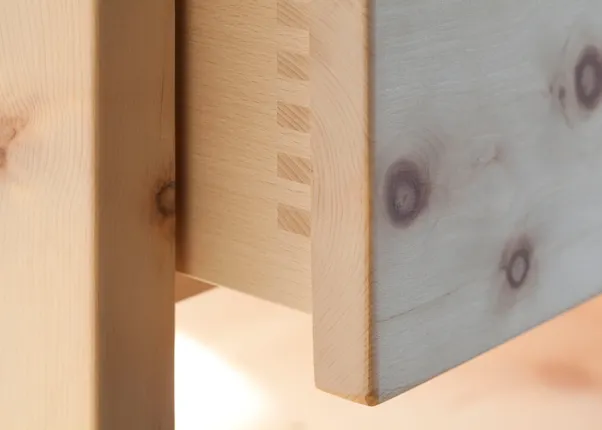Detail einer Schwalbenschwanz-Holzverbindung an einer Schublade aus hellem Massivholz