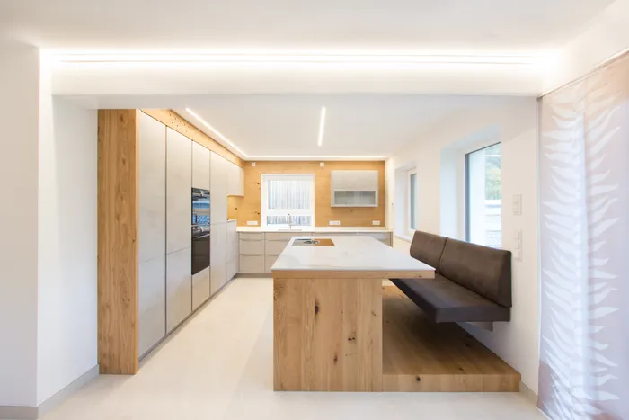 Moderne Küche mit Beton und Eiche mit Sitzplatz an der Kücheninsel