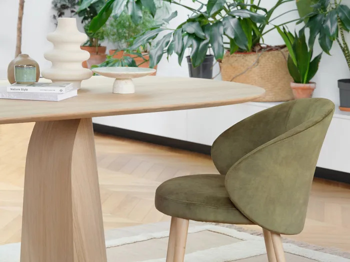 Moderner Essbereich mit grünem Samtstuhl, Holztisch und Zimmerpflanzen