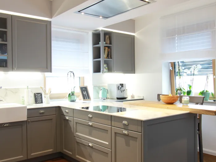 Moderne Küche mit grauen Schränken, Holzarbeitsplatte und Fischgrätparkett