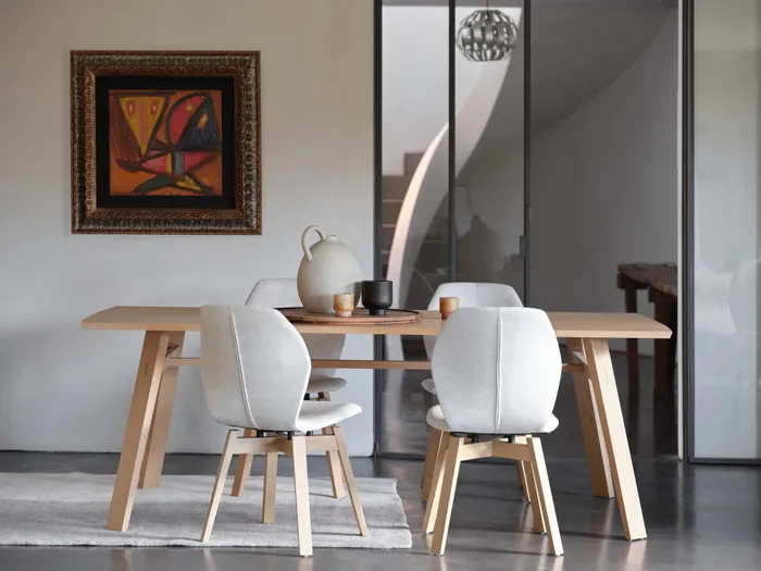 Moderner Essbereich mit Holz-Esstisch, hellen Stühlen und abstraktem Gemälde an der Wand