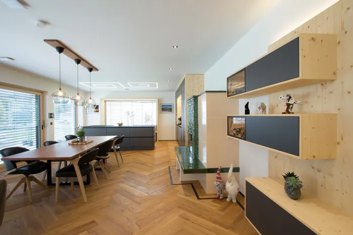 Modernes Ess- und Wohnzimmer mit Holzfußboden, Hängelampen und offenen Regalen